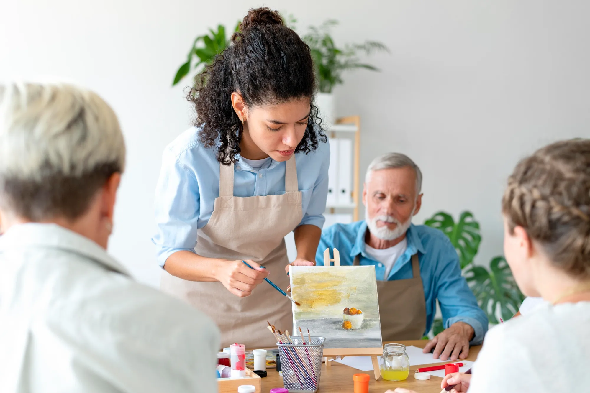 A woman teaching an art class to a small group